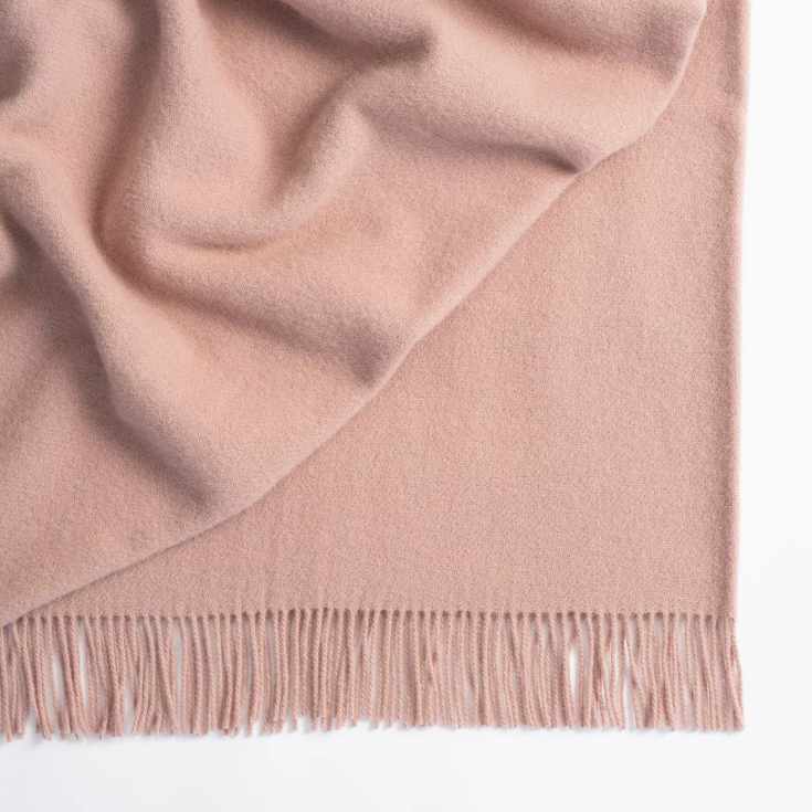 Shop the Nevis lambswool throw 130x200cm – made from 100% New Zealand wool with a soft, thick texture and tassel fringe, perfect for cosy living and gifting.