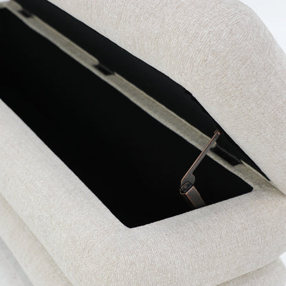 A sculptural upholstered bench with concealed storage, designed for soft comfort and everyday functionality.