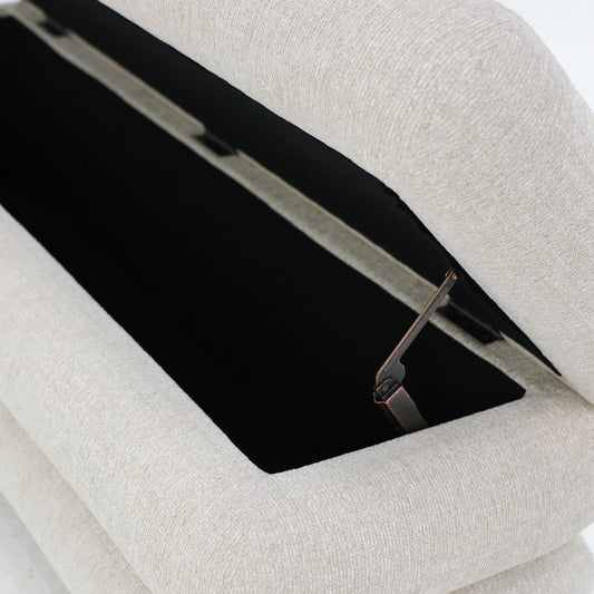 A sculptural upholstered bench with concealed storage, designed for soft comfort and everyday functionality.