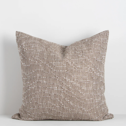The Adler 55x55cm cushion features a subtle flecked weave in warm tones, adding refined texture and versatility to your interior styling.