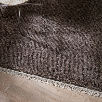 Brown textured rug with a wooden bench and coffee cup on a wooden floor. 100% NZ Wool