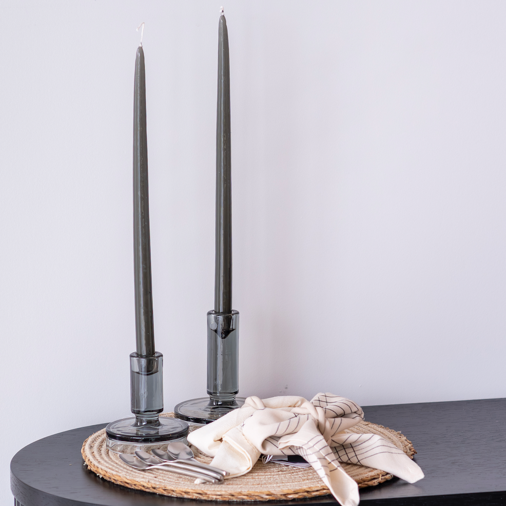 Decorative setup with black candlesticks on a textured surface against a light background